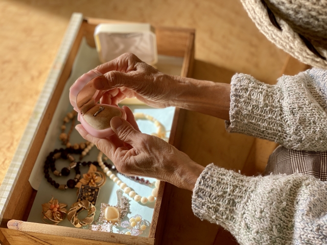 思い出の品に向き合う中年女性の後ろ姿