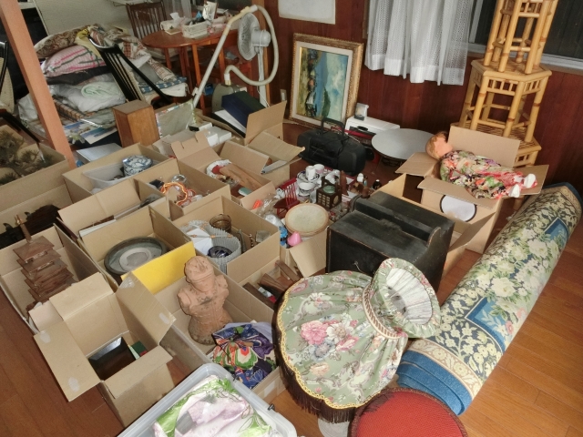 部屋の荷物を整理しながら確認する女性